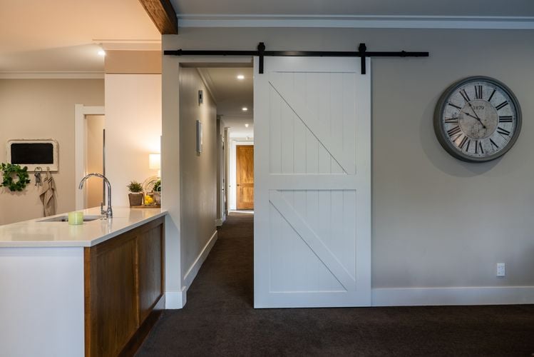 Large white wooden sliding door entering into hallway from kitchen