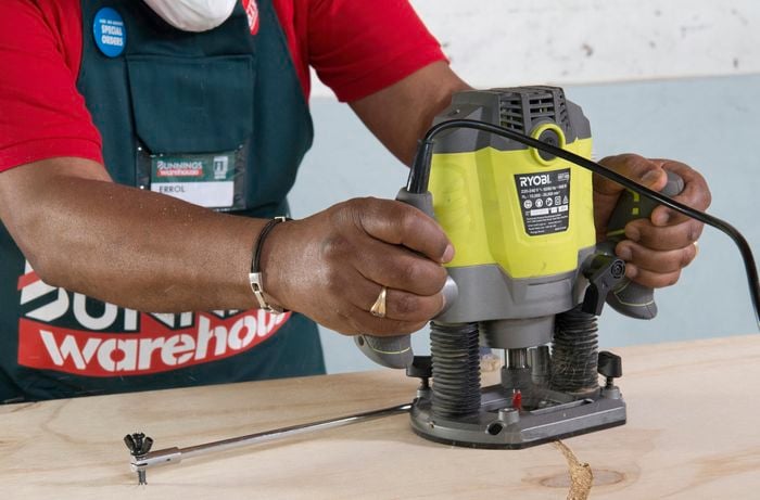 Person using router to cut circular tabletop out of timber