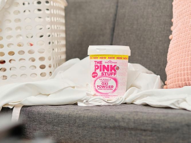 A container of Oxi Powder on a couch with washing.