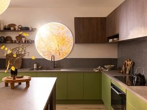 Kitchen with hardwood floor and wooden island, kitchen cupboards painted dark green
