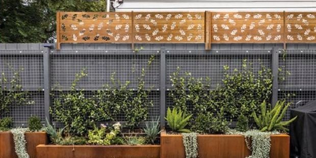 Outdoor area with garden beds, vertical garden and fence extension.