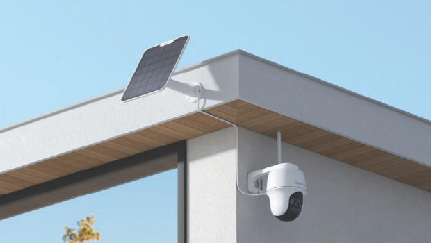 A smart security camera and solar panel attached to the top corner of a modern house.