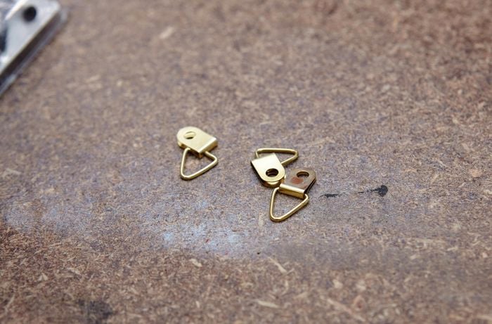 Flattened picture frame hangers on a workbench