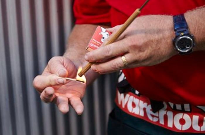 A Bunnings team member lighting a sandalwood stick