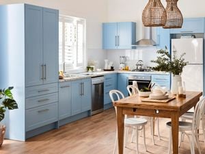 Kitchen with blue cabinets and marble benchtops.
