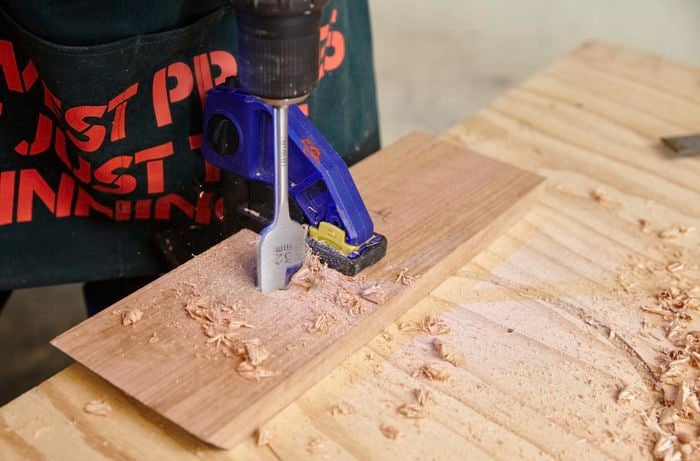 A bore spade drill bit being used to drill a hole in a length of timber