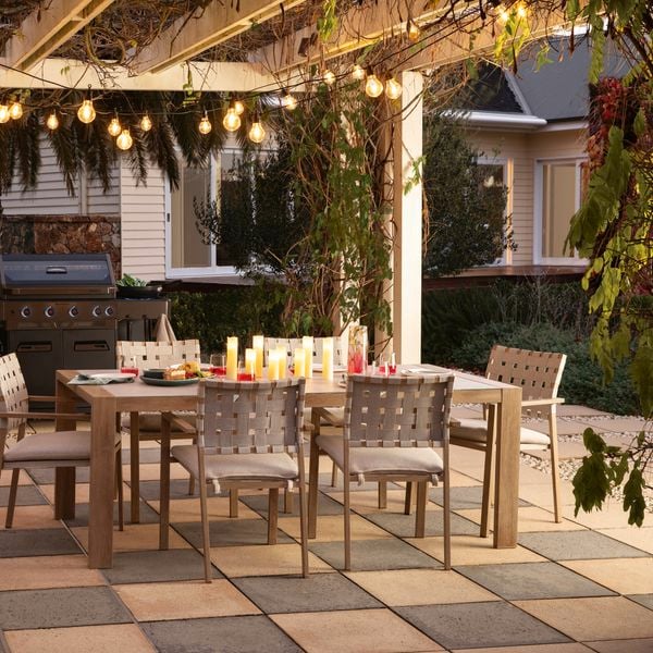 Outdoor entertaining area with a table and chairs, barbecue and party lights.
