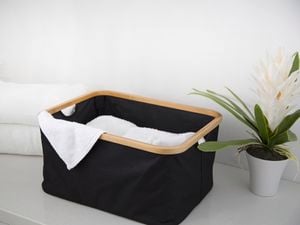Laundry basket with towel in it and orchid.