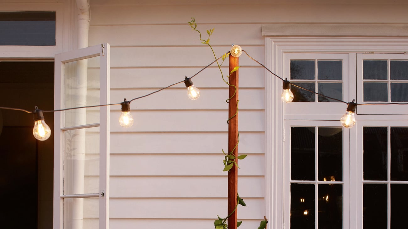 Festoon lights are strung above outdoor furniture