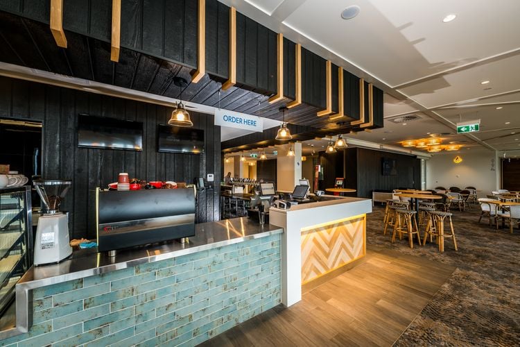 Interior of a hotel bar showing black timber cladding on the wall and ceiling