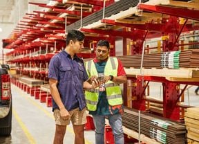 A Bunnings Warehouse team member shows a tradie how to use the PowerPass app in-store