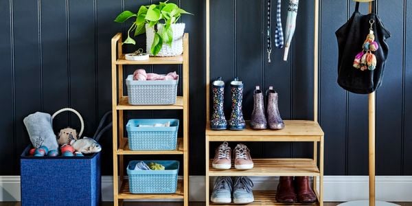Organised timber shelving rack, with kids boots and shoes and hanging bag and umbrella off hooks. Separate hat stand with hats and small four tier rack with basket organisers.
