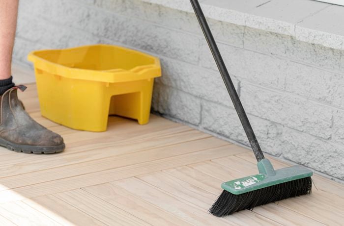 Person brushing decking.
