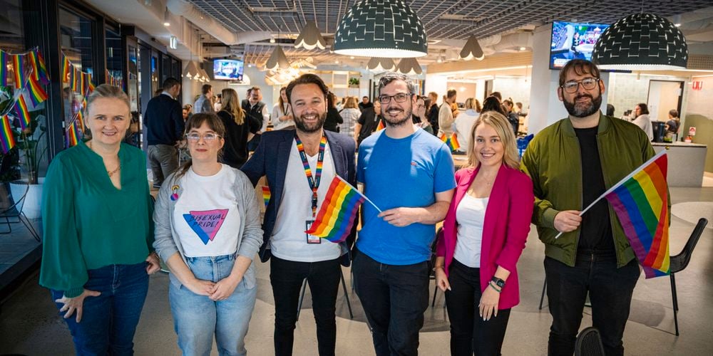 Team in shot with pride flags