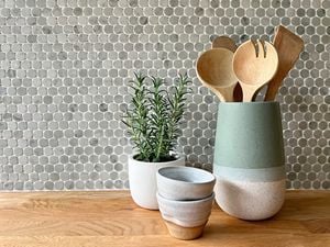 Decor on table in front of mosaic tile splashback.