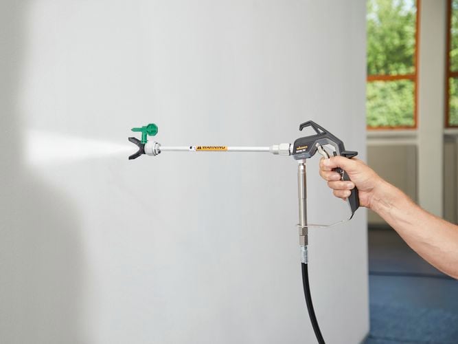 Wagner Control Pro Hybrid Gun attached to 30cm extension with Control Pro Tip 311 to spray a wall with off-white paint.