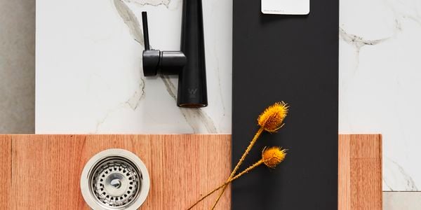 kitchen flat lay matt black tapware, marble splashback and timber benchtop
