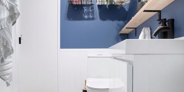 Renovated bathroom with blue walls, new toilet.