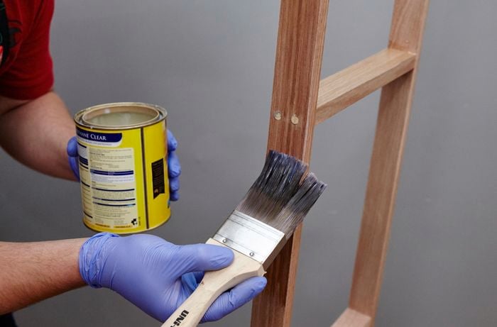 The frame for a shoe storage rack being varnished
