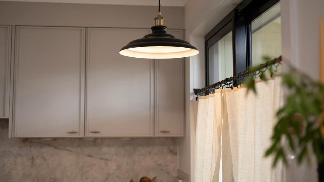 An elegant black and silver hanging light over a kitchen island.