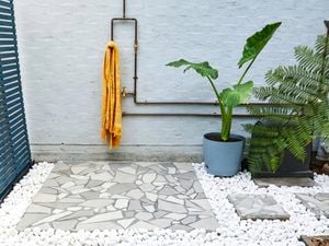 Outdoor shower with crazy paving and plants.
