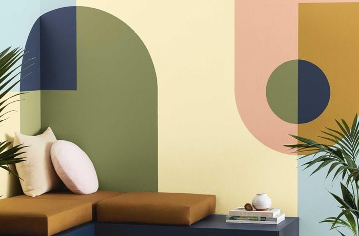 lounge with geometric feature wall, cushions and a rug