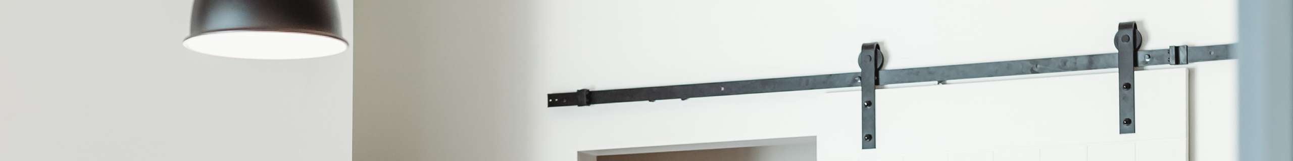 A hanging lamp and a door track connected to a wall.