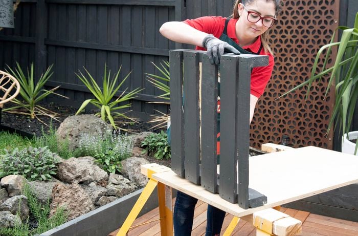 Part of a pallet being painted Bunnings teal