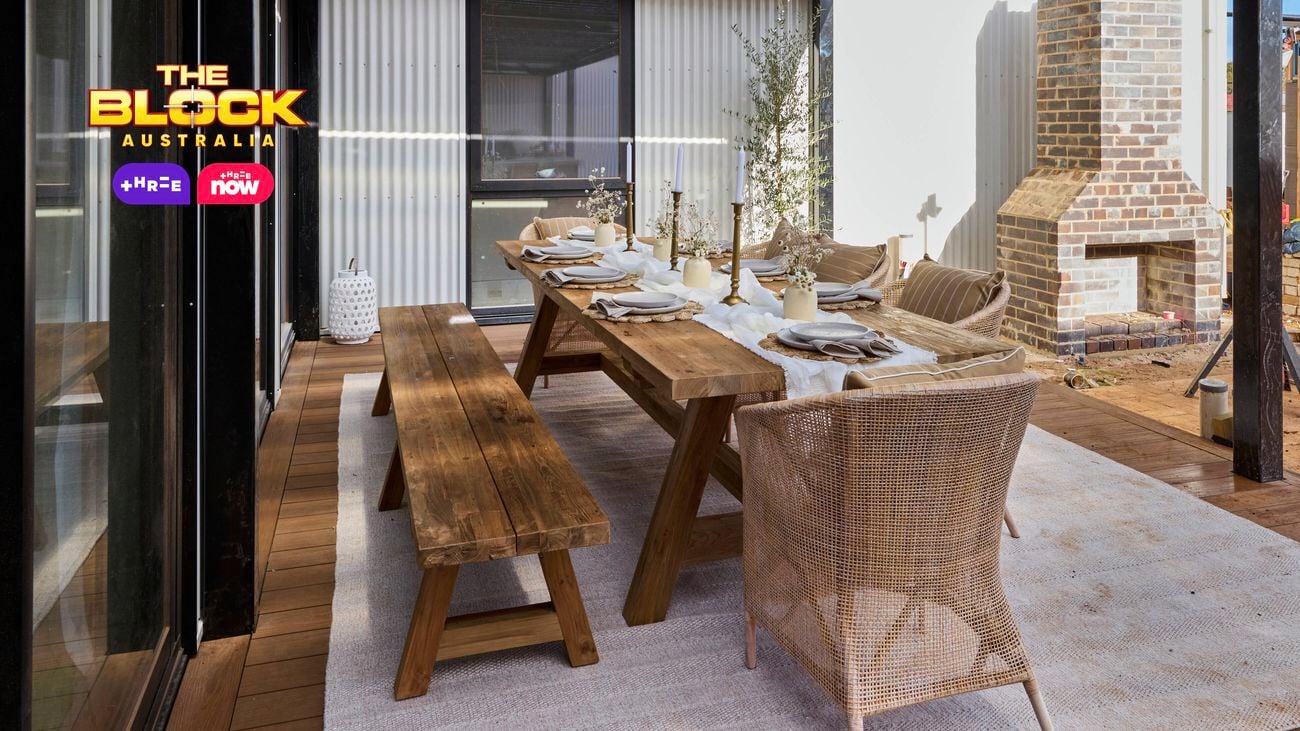 An outdoor area with a table and chairs around it under cover.