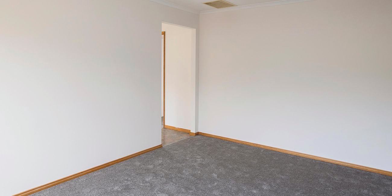 Living room with blue feature wall, white couch, white coffee table and pictures hanging on the wall.