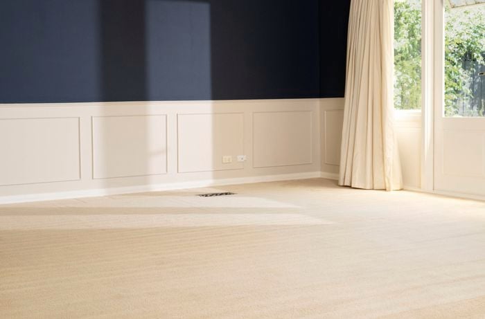 A freshly cleaned beige carpet is drying to prevent dirt from settling into damp fibres and to avoid mould or mildew growth.