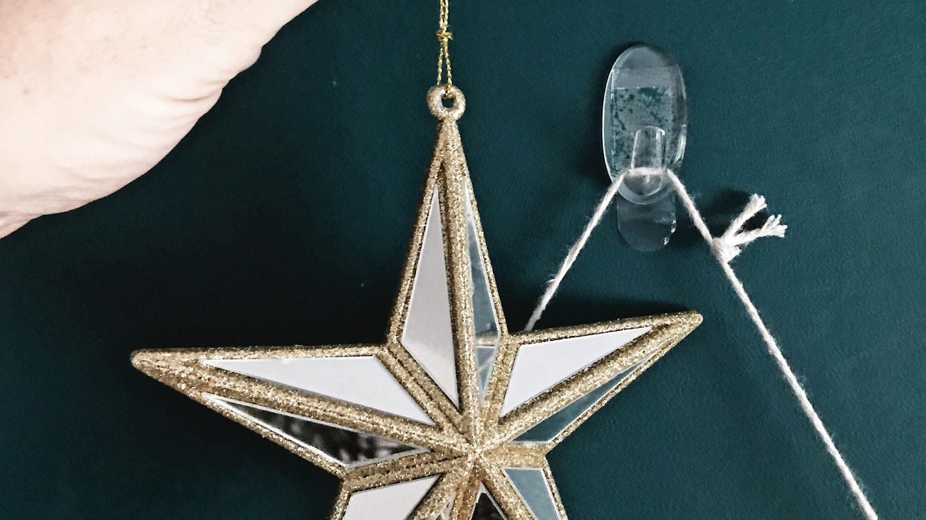 3M hooks hanging on a green wall with Christmas star decorations.