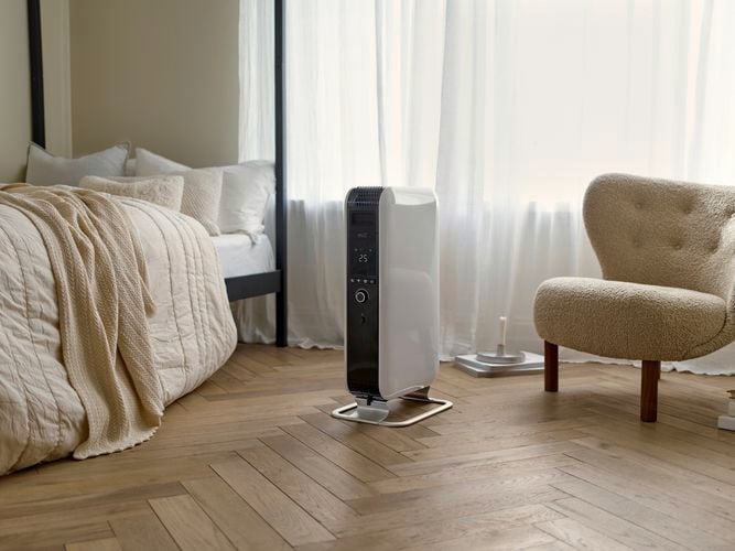 Air oil filled radiator in a bedroom on timber floorboards.