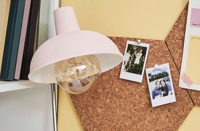 Corkboard organiser with photos pinned to it.