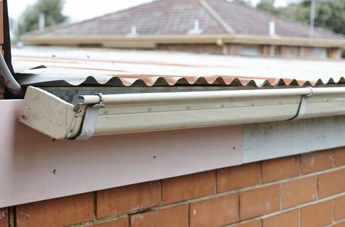Guttering hanging from a new section of timber fascia board