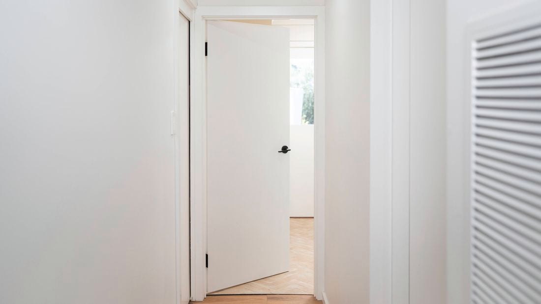A fully installed door opens easily within the frame, indicating correct fitting and secure hinge installation.