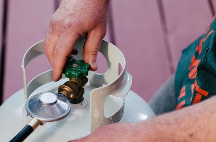 Person turning tap on a gas bottle