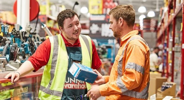 bunnings team member serving a customer in the power tool isle.