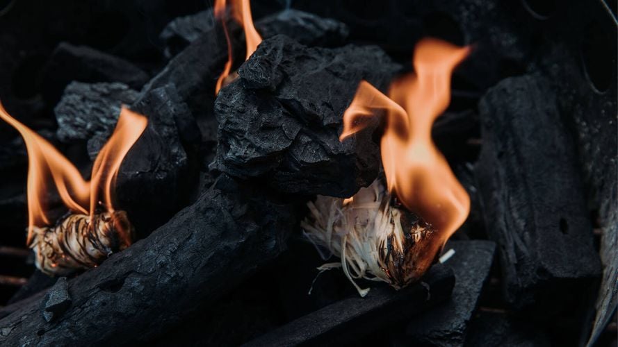 BBQ Firestarters nestled amongst charcoal, having been just lit up to heat the charcoal