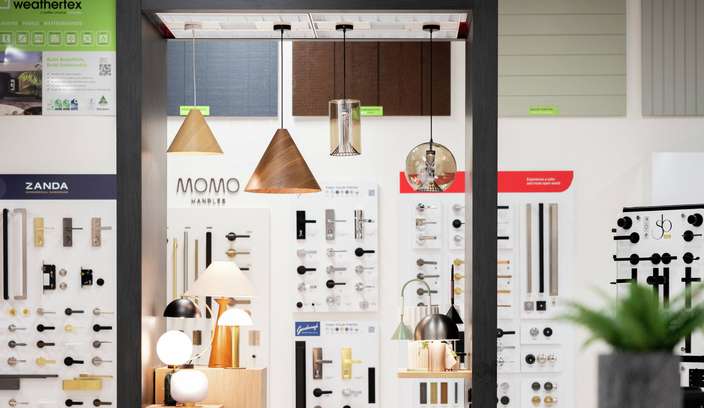 Building products and hardware showroom featuring decorative lighting displays, door hardware sample boards and wall cladding selections.