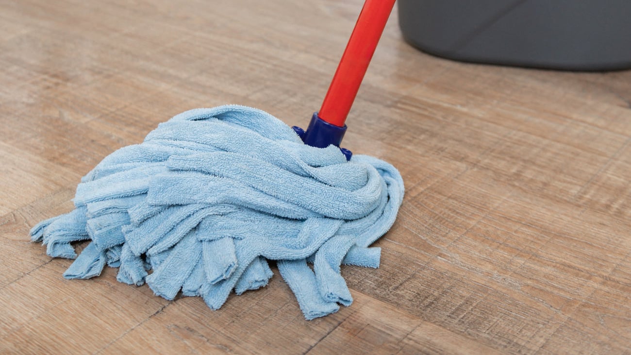 A mop being used on a hardwood floor