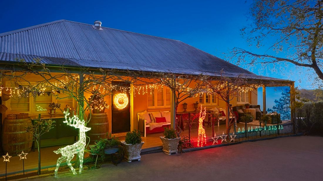 Christmas lights and decorations at the front of an old style house at night