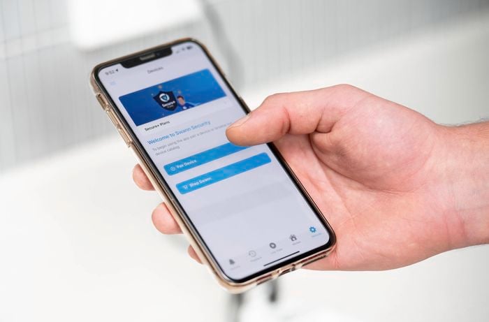 A person is pairing the app on a smartphone to check the Wi-Fi signal strength.