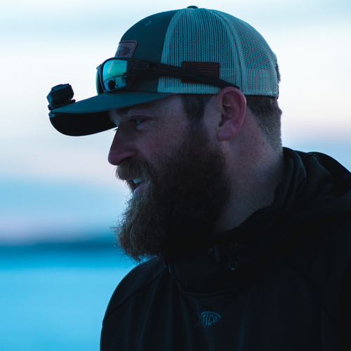 Side profile of man wearing hat with hat clip light attached.