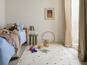 Child’s bedroom with bed, toys on rug, and soft natural light