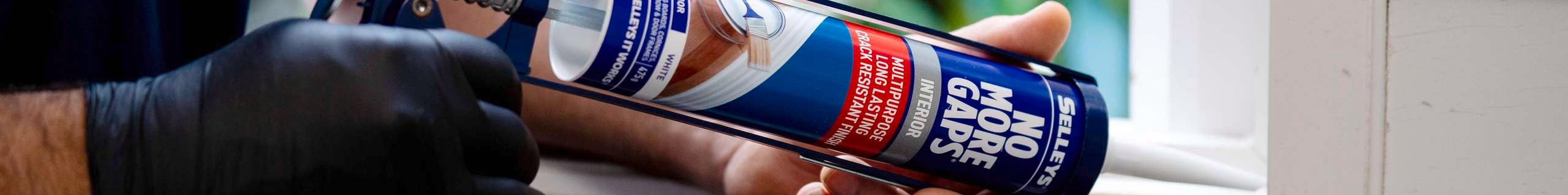 A close up of a person caulking.