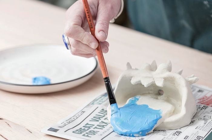 A clay monster head being painted