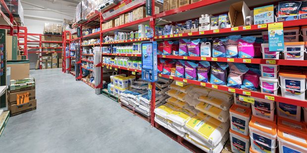 Wide aisle at Bunnings showing shelves stocked with pool chemicals, cleaning products and supplies in a warehouse‑style store.