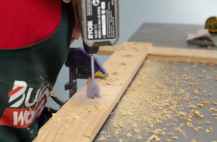 Person drilling holes in timber