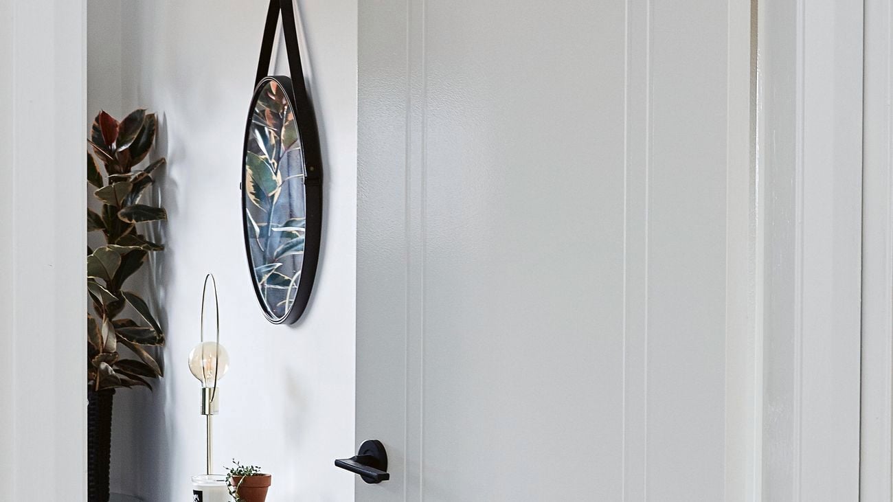 White internal door with a sleek black handle.